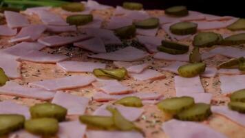 Hands preparing a pizza. Frame. Cook in the kitchen putting the ingredients on the pizza. Pizza concept. Production and delivery of food. Closeup hand of chef baker in white uniform making pizza at video