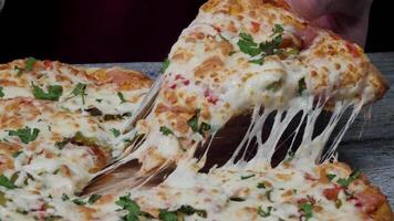 pasto tempo a pizzeria, uomo assunzione un' fetta di il Pizza tiro con molto magro profondità di campo. telaio. mano tagliare fetta di Pizza e prendere esso, vicino su, macro sparo. Pizza e fetta di Pizza nel mano su il video