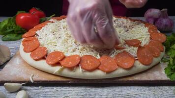 Pizza art. le processus de fabrication Pizza. Cadre. Frais original italien brut pizza, préparation dans traditionnel style. main de chef boulanger dans uniforme ajouter pimenter dans Pizza après préparation à restaurant video