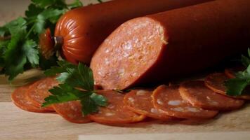 Sliced pepperoni sausages on wooden cutting board. Frame. detail of sliced pepperoni sausages on wooden cutting board. Chorizo salami sausage on rustic background. Meat cold cuts. video