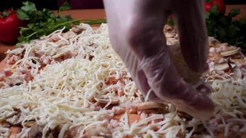 tillsats sås. italiensk pizza förberedelse. ram. ost varelse spridning på tomat sås på pizza bas. närbild hand av kock bagare i vit enhetlig framställning pizza på kök video