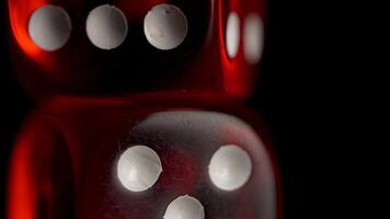 Two red casino dices on the black background. Shot glasses with dice and ribbon. risk concept - playing dice at black wooden background. Playing a game with dice. Red casino dice rolls. video