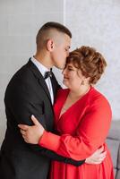 mother helps her adult son prepare for the wedding ceremony. An emotional and touching moment at a wedding. A mother hugs her son photo