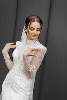 portrait of a young bride in a white wedding dress with sleeves. Professional hairstyle and natural make-up. Wedding concept photo