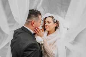 Wedding couple in love. A beautiful bride and an elegant groom tenderly embrace and enjoy the day. A stylish couple of newlyweds. Concept of marriage photo