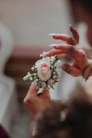 wedding boutonniere of flowers in the hands of the bride. Wedding details. The first meeting of the bride and groom. The bride is waiting for the groom. photo