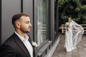 el novia en un de moda vestir y un velo va a el novio. el concepto de un hermosa boda. foto