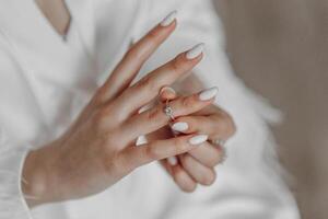 the bride wears a diamond engagement ring. Beautiful hands of the bride. photo