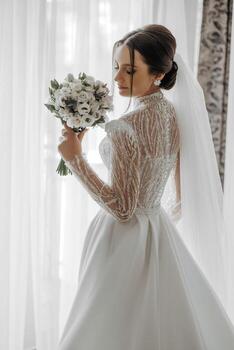 Moda retrato de un hermosa novia en un lujoso Boda vestir con cordón y cristales en un Arábica interior estilo. hermosa novia con un ramo de flores de flores preparación para el Boda ceremonia. foto