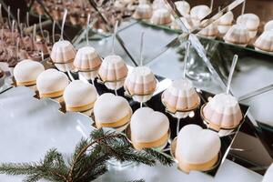 un delicioso boda. blanco pastel decorado con flores caramelo bar para un banquete. celebracion concepto. de moda postres mesa con dulces, dulces. frutas foto