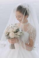 The bride holds a bouquet and poses during a walk in winter. Exquisite dress and hairstyle. photo