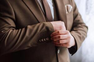 Cropped photo of man in brown suit. Business style. Groom in a suit