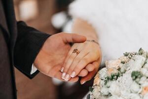 el novio pone un anillo en el de la novia dedo. intercambiar de anillos contento Pareja celebrando Boda al aire libre en invierno. foto