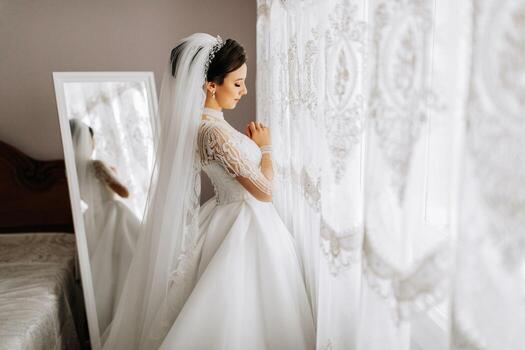 fashion portrait of a beautiful bride in a luxurious wedding dress with lace and crystals. Preparation for the wedding ceremony. photo