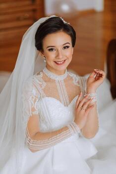 Moda retrato de un hermosa novia en un lujoso Boda vestir con cordón y cristales en un Arábica interior estilo. hermosa novia con un ramo de flores de flores preparación para el Boda ceremonia. foto