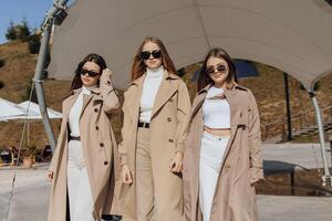 Three beautiful young teenage girls are having fun together outdoors in an Italian town. Urban lifestyle. City center. Best friends in casual clothes. photo