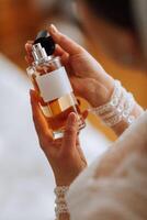 cropped view of woman in fancy dress holding bottle of luxury perfume photo