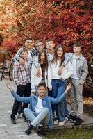 friendship, movement, action, freedom and people concept - group of happy teenagers or school friends posing and having fun outdoors against nature or forest background. photo