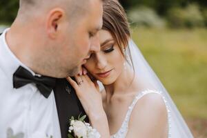 Wedding. Love and couple in garden for wedding. Celebration of ceremony and commitment. Save the date. Trust The groom embraces the bride in the mountains on the background of the forest photo