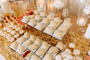 Candy bar for a wedding. Candy bar standing festive table with desserts, cupcakes and macarons. Beautiful and tasty. photo