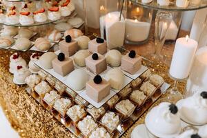 Candy bar for a wedding. Candy bar standing festive table with desserts, cupcakes and macarons. Beautiful and tasty. photo