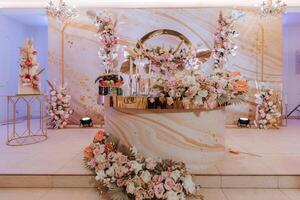 Luxurious, elegant decoration for the wedding reception, flower compositions for the wedding photo zone, decorated with flowers for the bride's prisidium