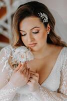 Beautiful bride in a luxurious wedding dress with a fashionable wedding hairstyle, professional make-up. Close-up portrait of young gorgeous bride in room from morning. High quality photo. photo