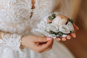 Boda flor en el ojal en el manos de el novia. el primero reunión de el novia y novio. el novia pone en un botín terminado el del novio chaqueta foto