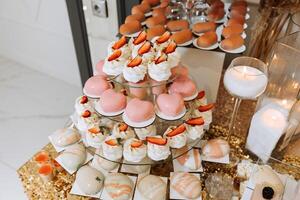 Candy bar for a wedding. Candy bar standing festive table with desserts, cupcakes and macarons. Beautiful and tasty. photo