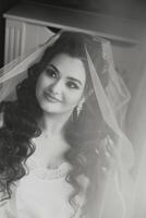 A beautiful brunette bride with a tiara in her hair is getting ready for the wedding in a beautiful robe in boudoir style. Close-up wedding portrait, photo. photo