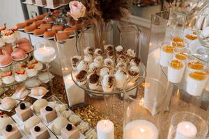 Candy bar for a wedding. Candy bar standing festive table with desserts, cupcakes and macarons. Beautiful and tasty. photo