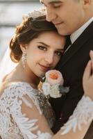 Winter wedding. A happy couple in wedding clothes are hugging and smiling in a winter park covered with snow on their wedding day. Winter love story of a beautiful couple in snowy winter weather photo