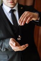 Playful excited young groom throwing wedding ring. Close-up photo of hands throwing wedding rings. High quality photo