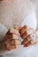 Close-up of an elegant diamond ring on a woman's finger with a modern manicure, sunlight. Love and wedding concept. Soft and selective focus. photo