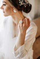 Luxurious wedding barrette on the head of the bride's hairstyle. The morning of the wedding preparation of the bride who touches the hairpin on her head with her hand. photo