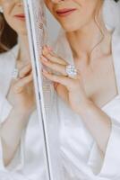 Close-up of an elegant diamond ring on a woman's finger with a modern manicure, sunlight. Love and wedding concept. Soft and selective focus. photo