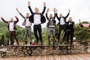 alegre, joven, energético testigos de el novio siguiente a el novio. amigos felicitar el novio. novio y su gracioso amigos teniendo divertido en el Boda día de el recién casados. foto