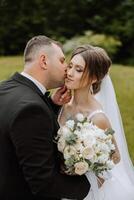 Wedding. Love and couple in garden for wedding. Celebration of ceremony and commitment. Save the date. Trust The groom embraces the bride in the mountains on the background of the forest photo