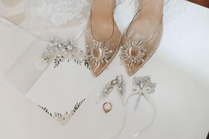 detalles de el novia. belleza es en el detalles. tacones altos nupcial zapatos. oro Boda anillo con un diamante. perfumes pendientes Boda en detalles. foto