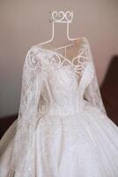 Bedroom interior with wedding dress prepared for the ceremony. A beautiful lush wedding dress on a mannequin in a hotel room. photo