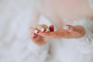 Close-up of an elegant diamond ring on a woman's finger with a modern manicure, sunlight. Love and wedding concept. Soft and selective focus. photo
