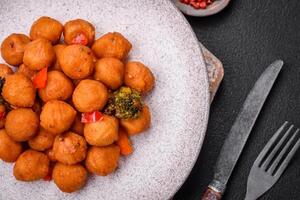 Delicious fried potato balls with vegetables, salt, spices and herbs photo