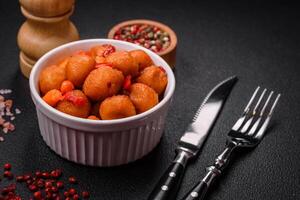Delicious fried potato balls with vegetables, salt, spices and herbs photo