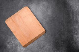 Empty wooden cutting board on a light texture background photo