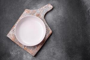 Empty round ceramic plate on a light texture background photo