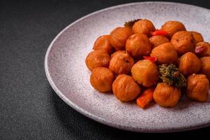 Delicious fried potato balls with vegetables, salt, spices and herbs photo