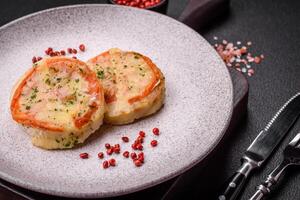 Delicious baked fish fillet with cheese, tomatoes, salt, spices and herbs photo