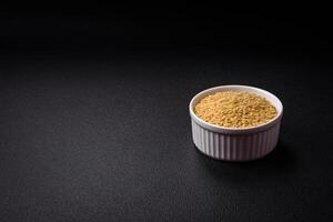 Raw risoni pasta made from durum wheat on a dark concrete background photo