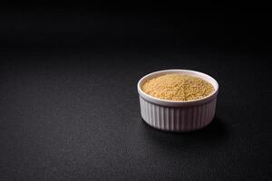 Wheat porridge couscous grains on a dark concrete background photo