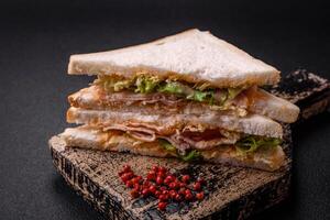 Delicious nutritious sandwich with toast bread, ham, tomatoes, cheese and sauce photo